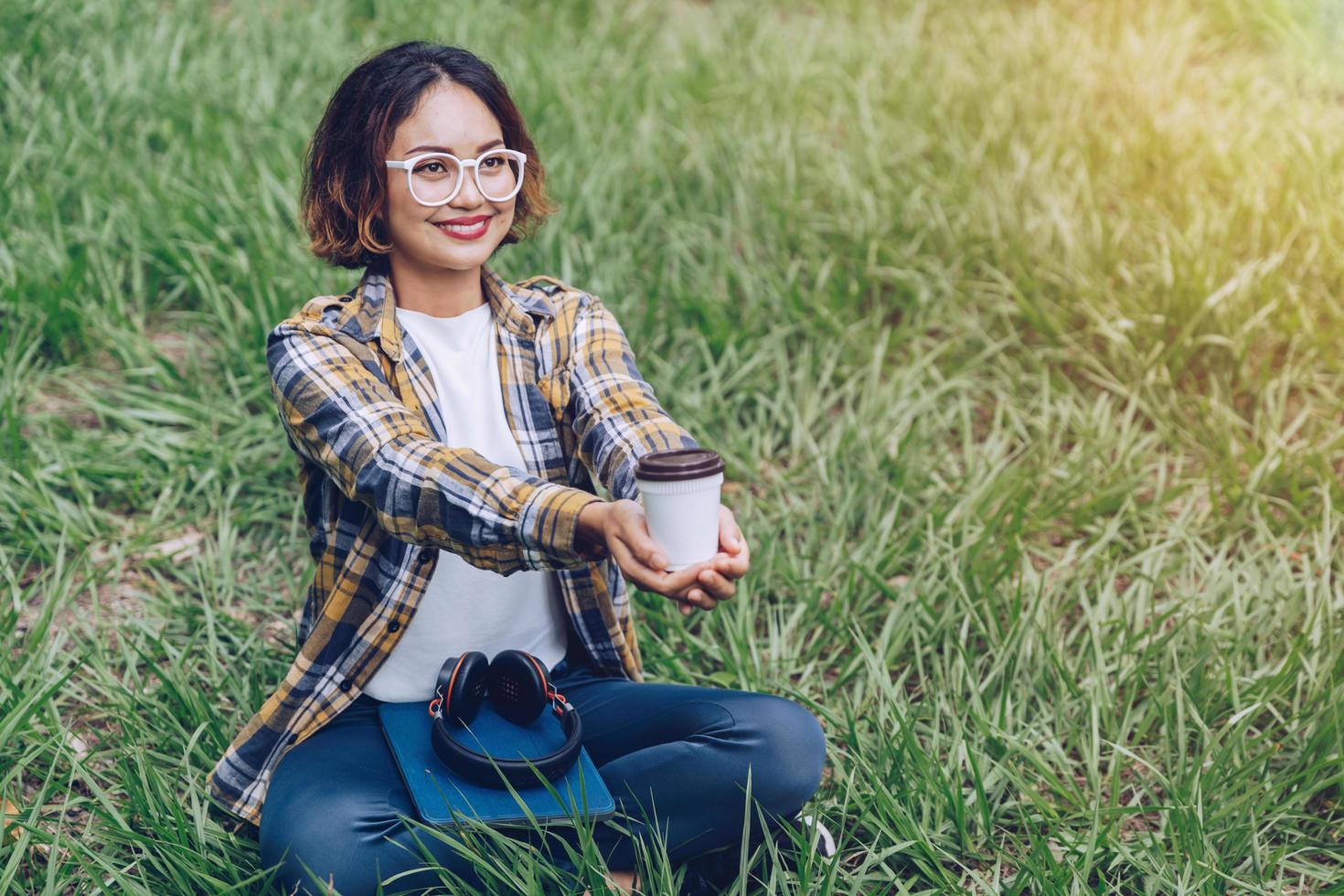 Asian woman sitting and drinking coffee in the garden photo