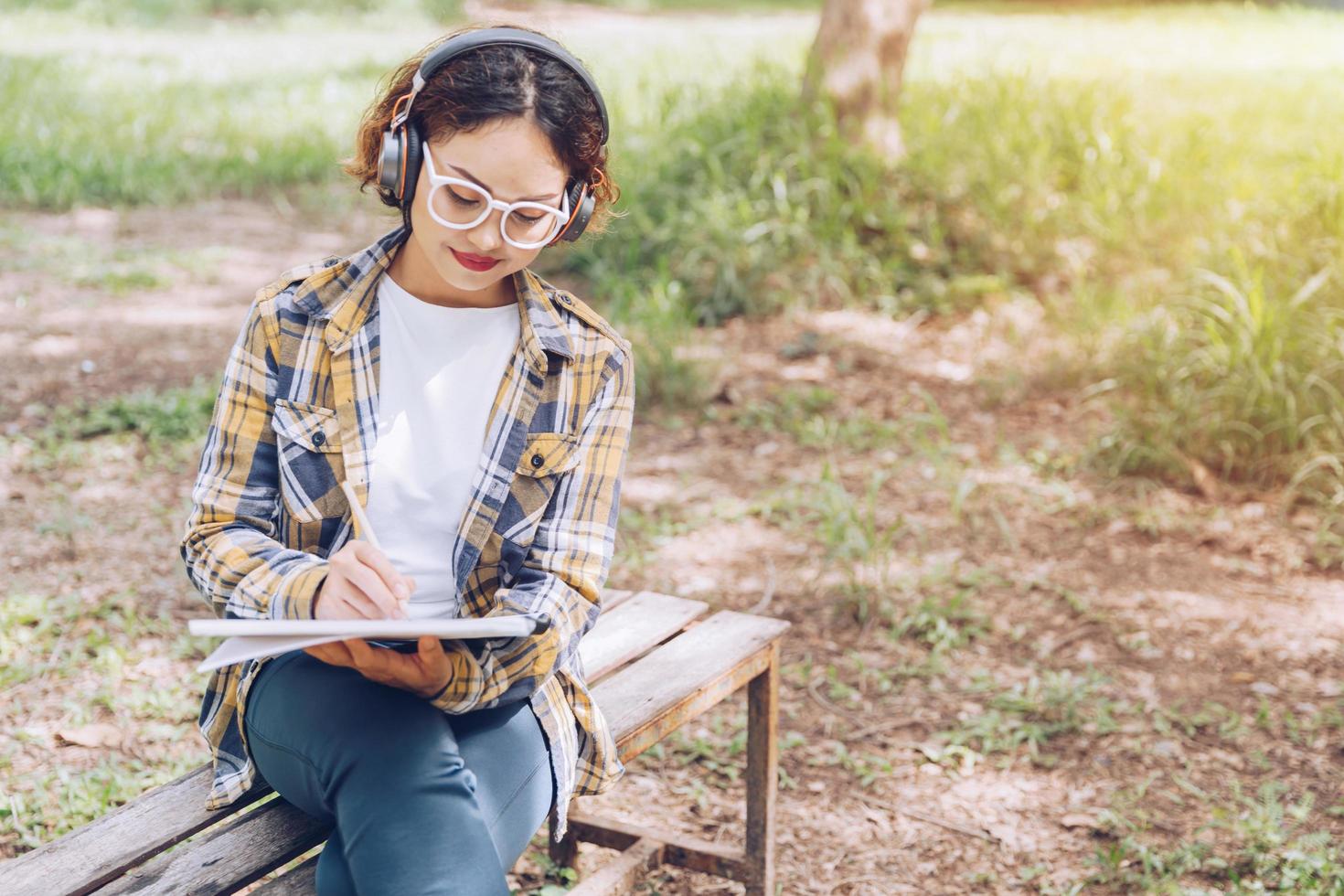 Asian woman sitting and writing in the garden photo