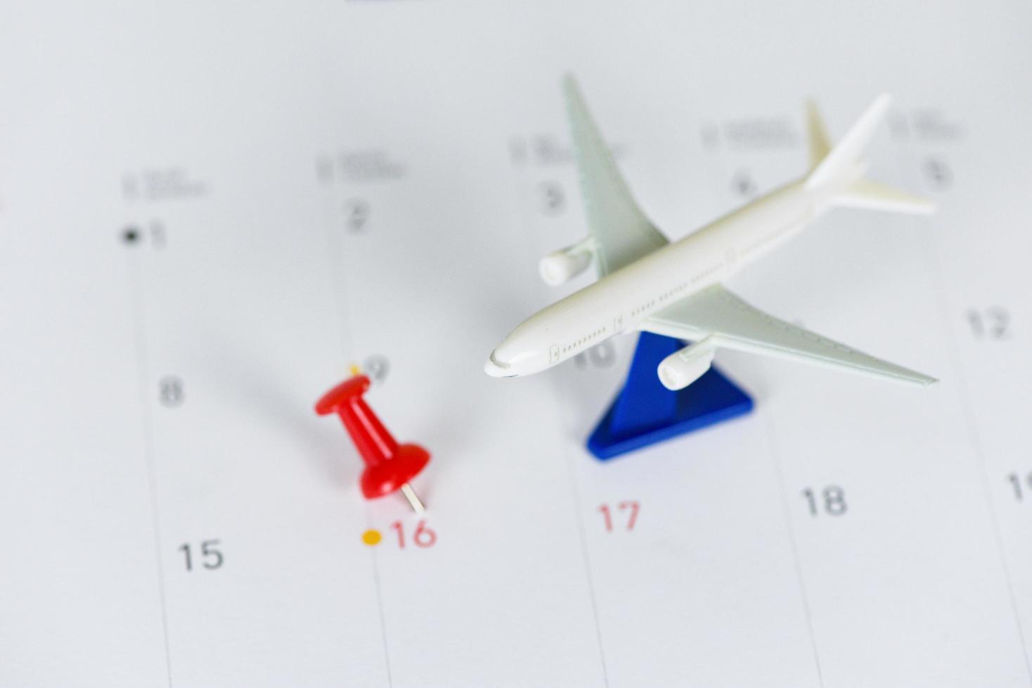 Travel planning with airplane destination points on a map red pin holiday on calendar - travel time or plan for travelling concept photo