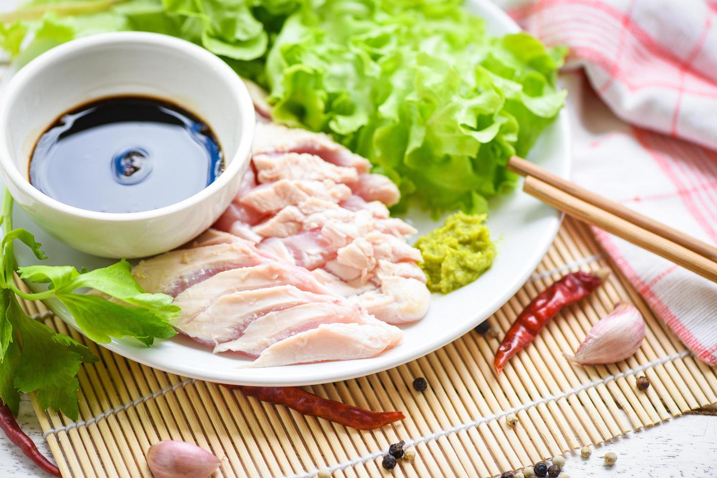 sashimi crudo pollo en blanco plato con wasabi salsa y vegetal ensalada ajo chile hierbas y especias tradicional japonés comida - pollo rebanadas carne filete foto