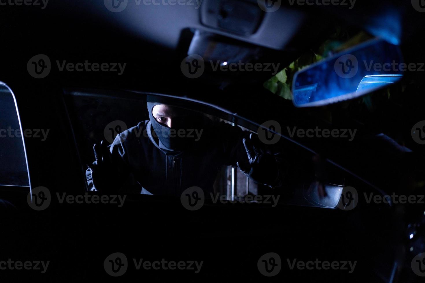 Robber looking thru car window. Car robbery concept photo