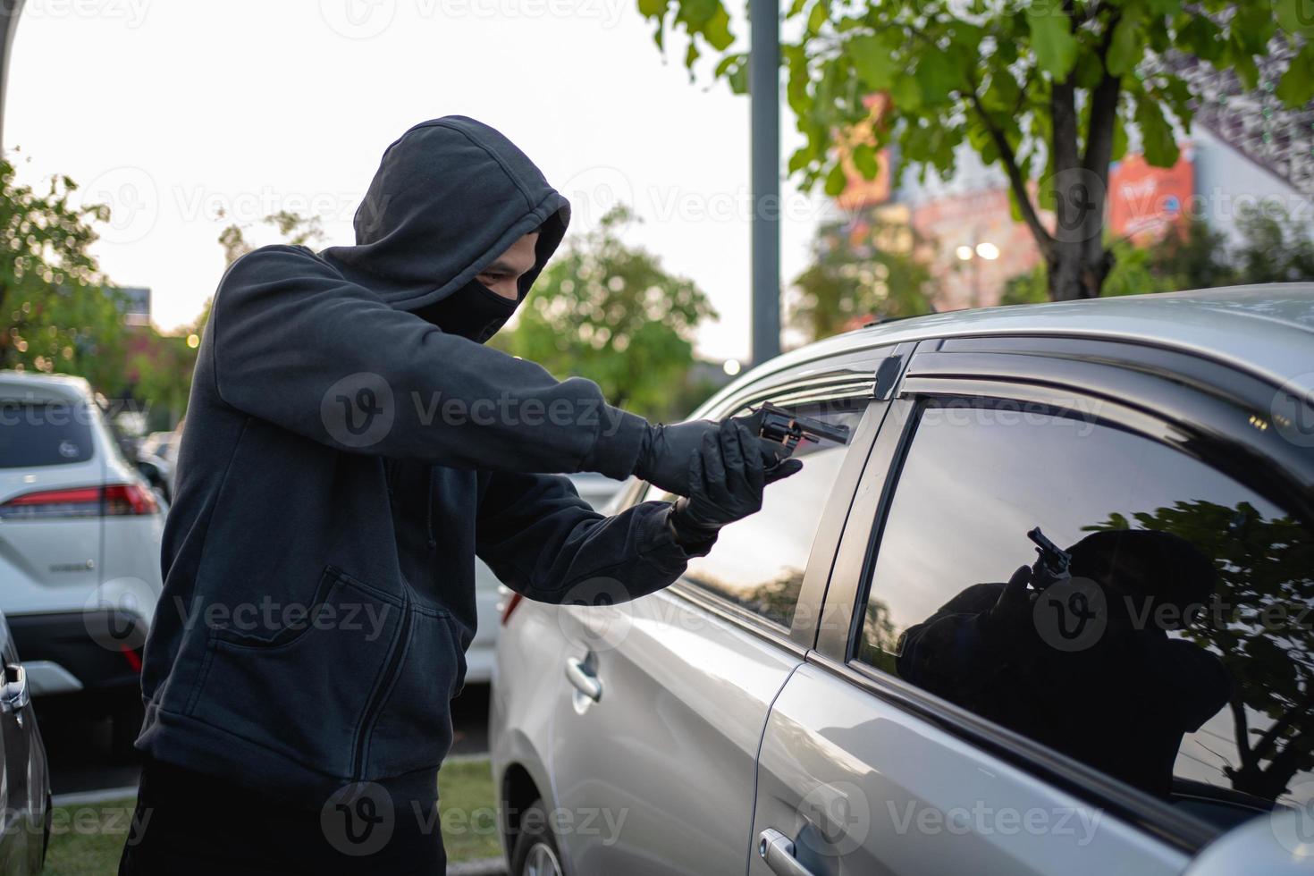 terrorista o coche ladrón señalando pistola a conductor foto