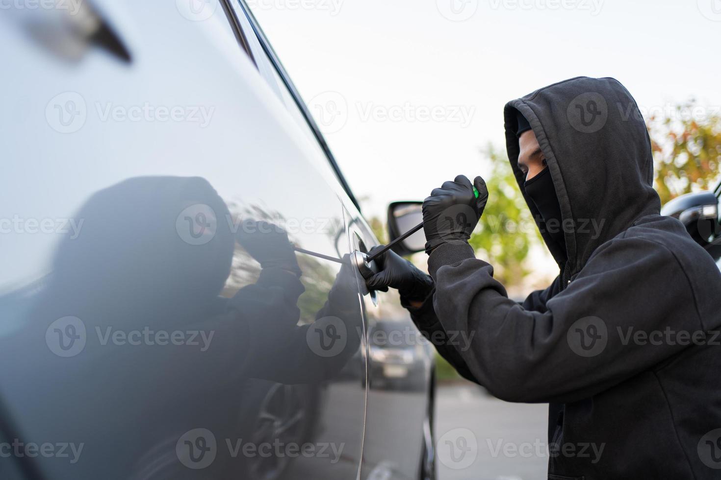 Man trying to smash a car in a parking lot photo