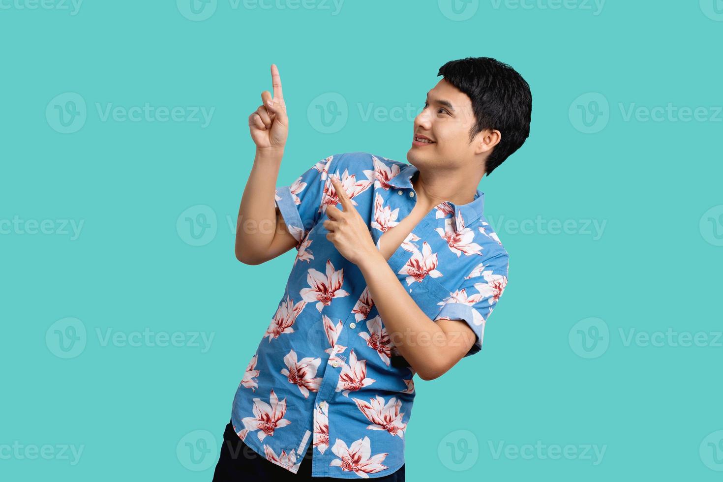 Handsome asian man pointed up on the top empty space. He wears a colorful shirt for Songkran Festival in Thailand. photo