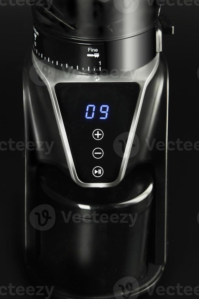 The electronic coffee mill on black background. photo