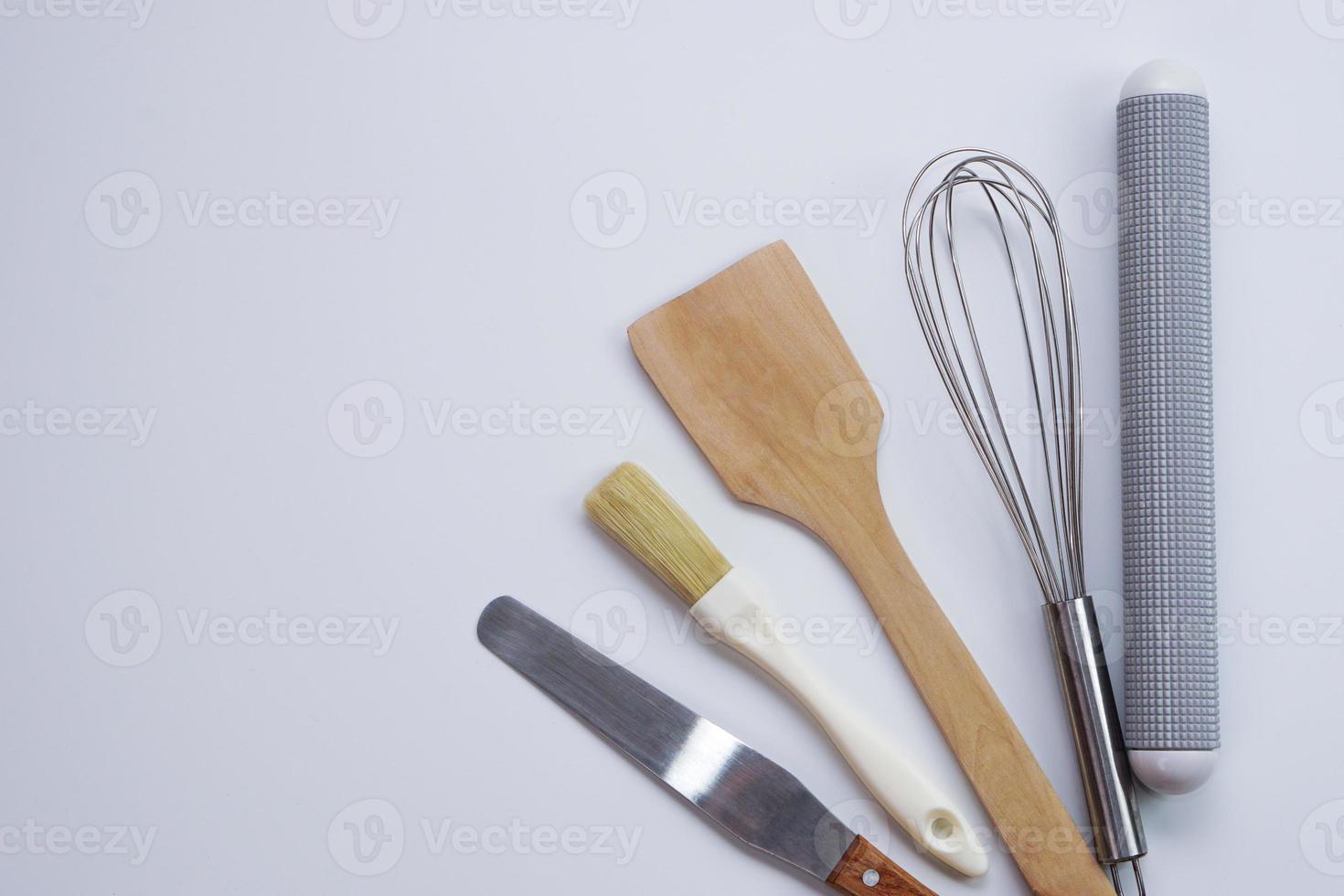 vista superior utensilios de cocina rodillo de madera, espátula de madera y batidor de huevos sobre fondo blanco. materiales o equipos de cocina para panadería. foto