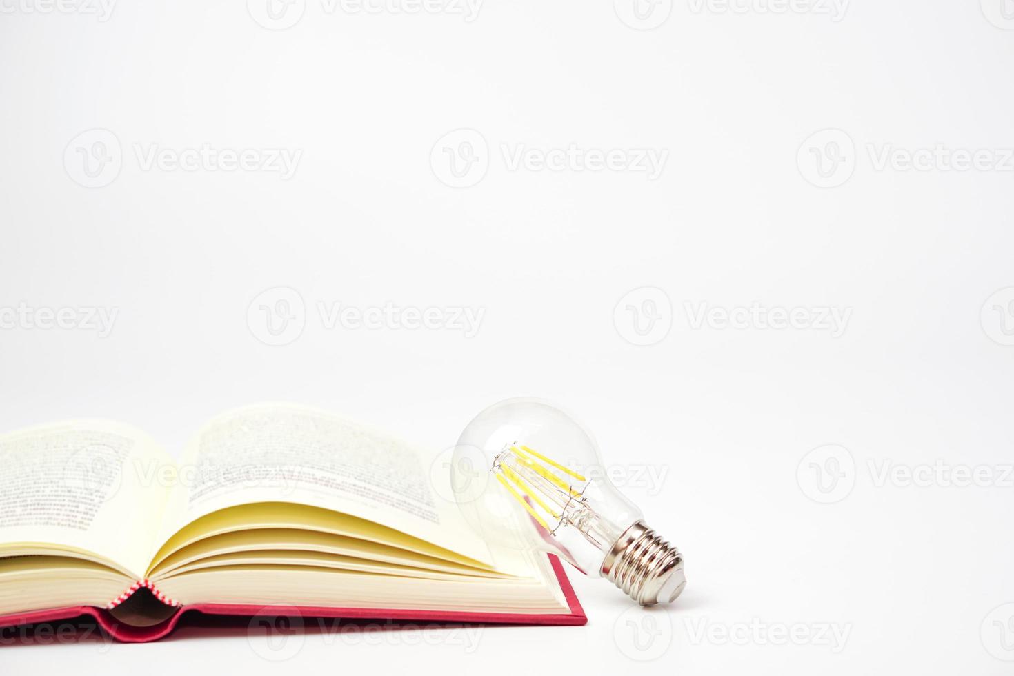 Light bulb glowing with book on white background. Concept of knowledge, wisdom, new ideas and creativity. photo