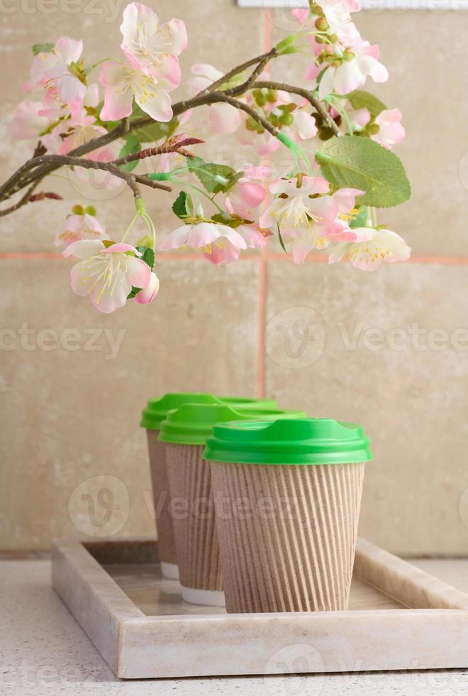 Paper brown cups with a plastic green lid for coffee and tea photo