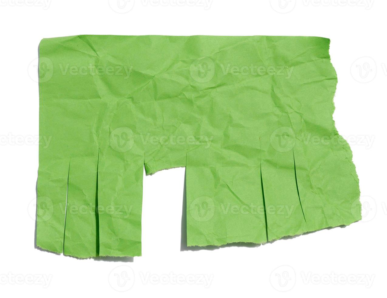 Green sheet of paper with torn edges for writing an ad on a white isolated background photo