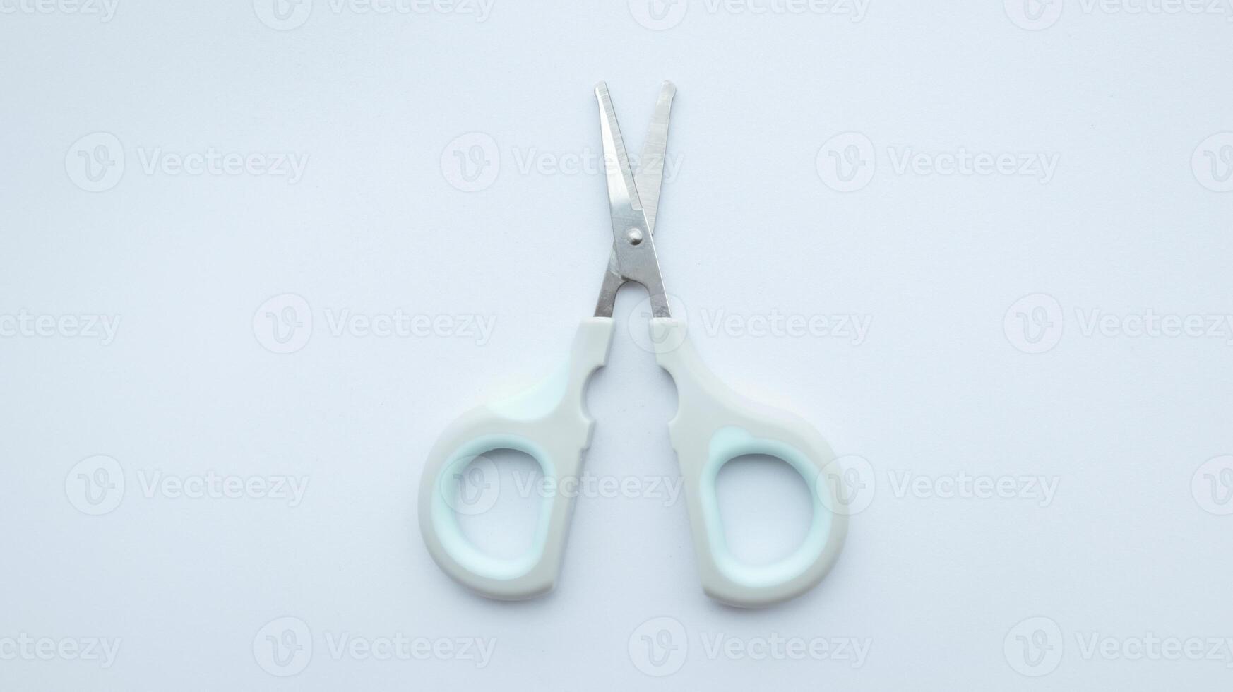 Small simple gray scissor isolated on white. photo