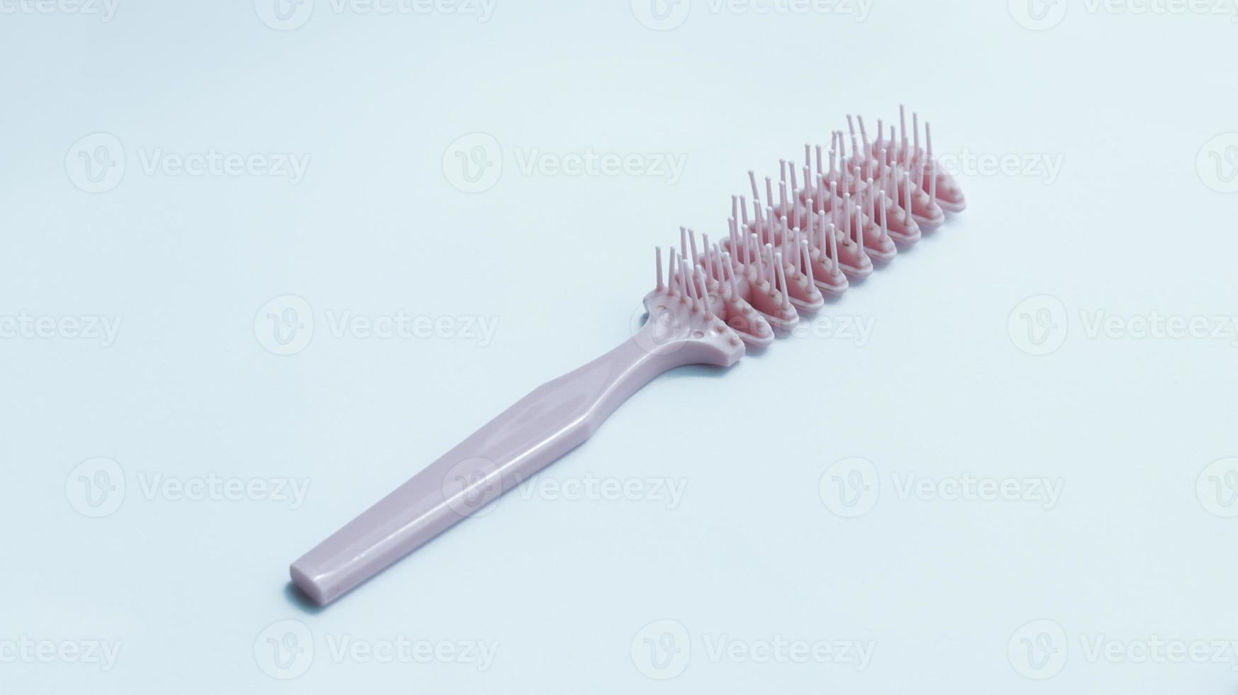 Woman stylish pink hair comb used for thick hair. photo