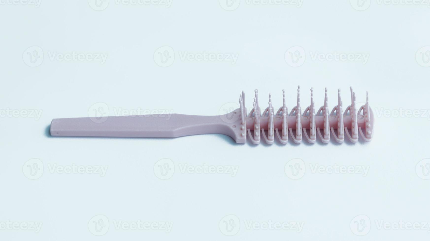 Woman stylish pink hair comb used for thick hair. photo