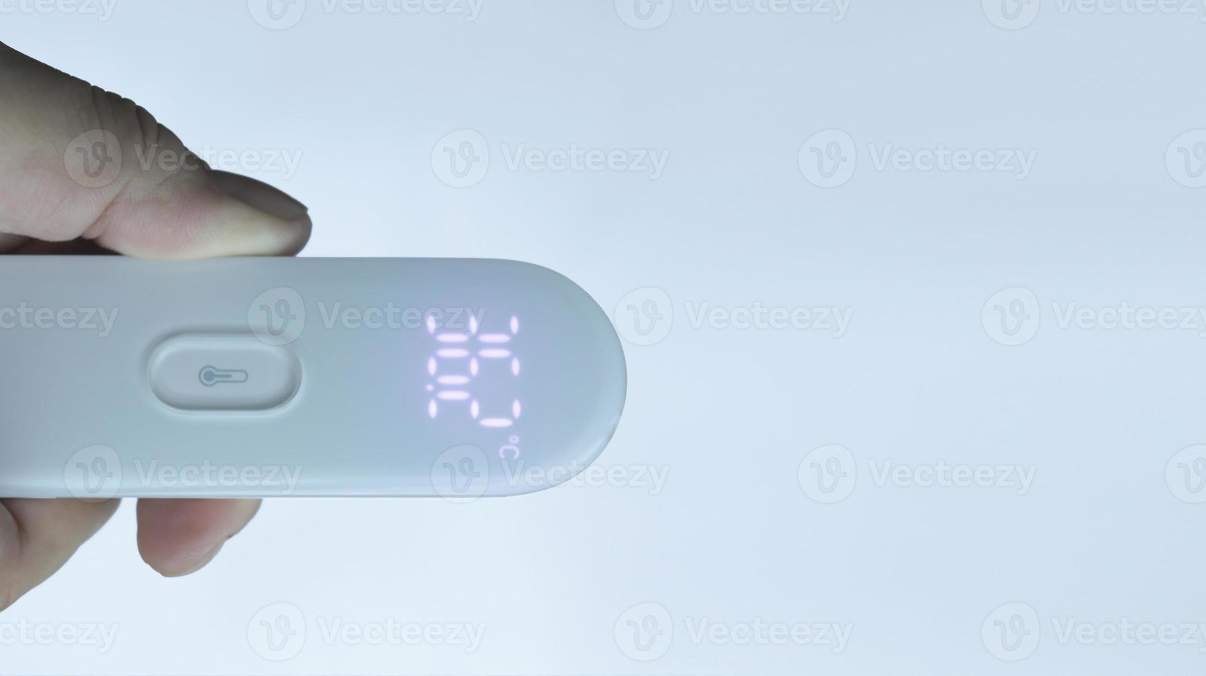 A hand holding digital thermometer showing normal temperature with isolated on white. photo
