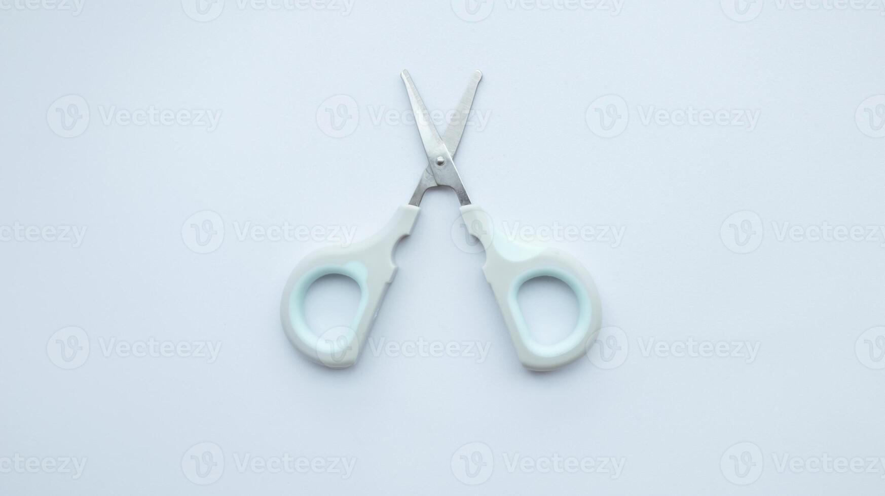 Small simple gray scissor isolated on white. photo