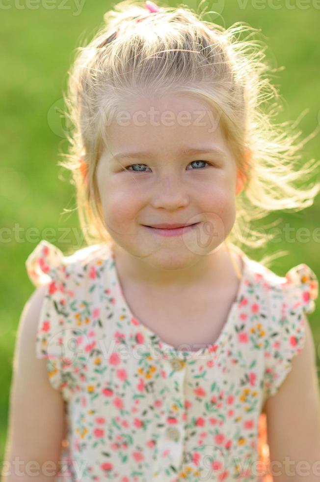 Little girl 3 years old in a summer sundress in the park. Summer time. photo