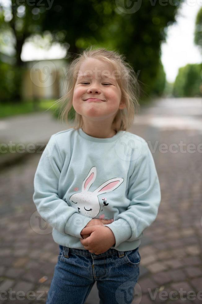 A little girl smiles funny at the camera. Close-up. photo