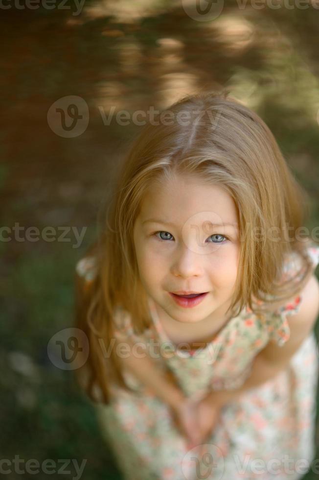 Little girl 3 years old in a summer sundress in the park. Summer time. photo