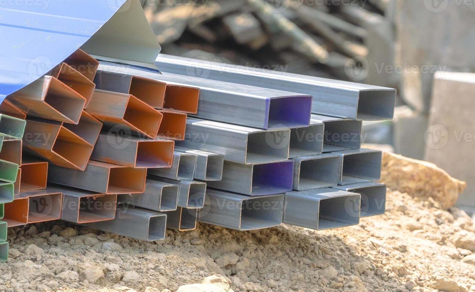 Group of square steel rectangle tubes metal iron production profiles pipe on the ground. Square metal pipes for background using metal pipes and rods, steel materials, building materials. photo