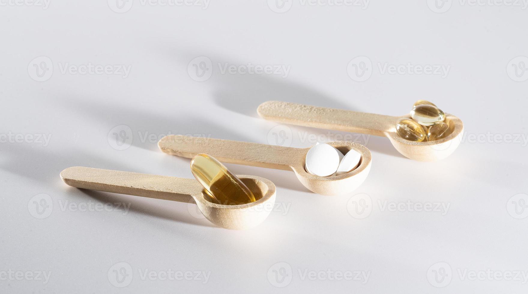 Spoons with vitamins, Vitamin D, omega 3, omega 6, Food supplement oil filled fish oil, vitamin A, vitamin E, flaxseed oil photo