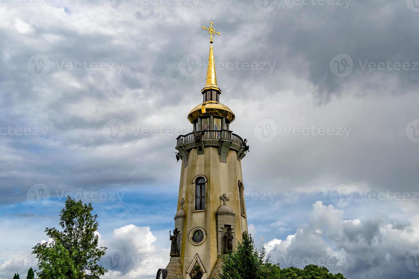 Cruz de la iglesia cristiana en alta torre campanario para la oración foto