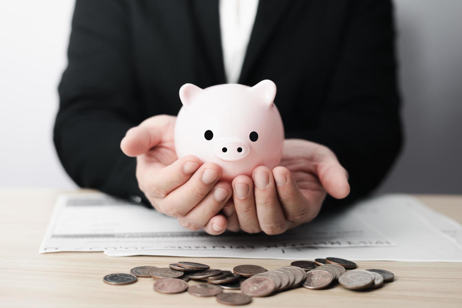 businessman holding piggybank on table, family finance plan concept, fundraising, superannuation, donation, saving, charity, investment, financial crisis concept. photo