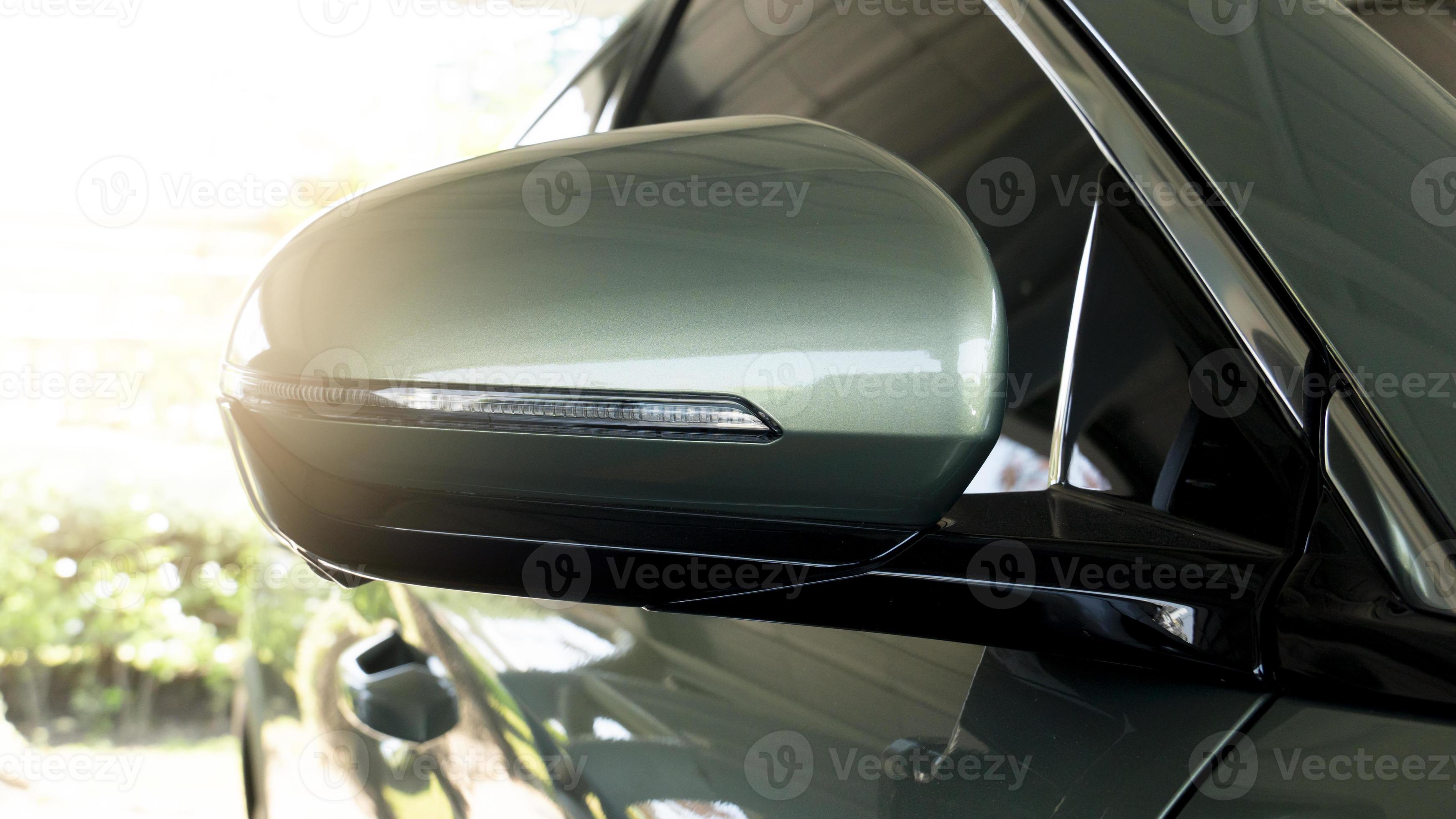 Back side of mirror wing of soft green car. Stop in the parking lot