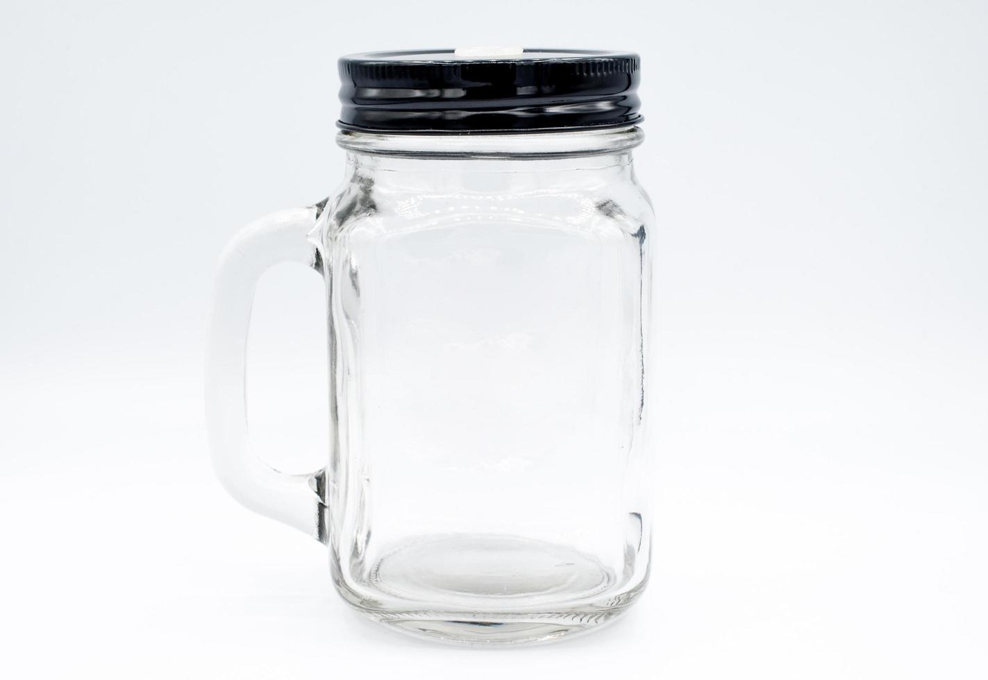 Glass bottle with black cap on isolated white background. An object with isolated background. photo