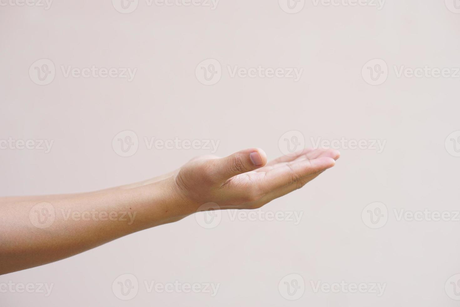 An Asian woman stretches her hand to the side like an empty object on her hand. photo