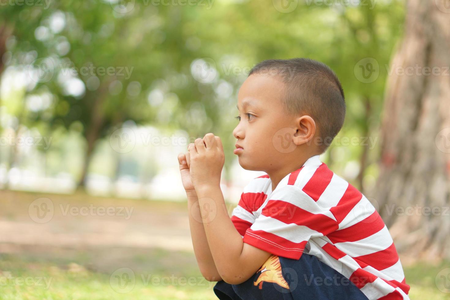 boy sitting sadly in the park photo