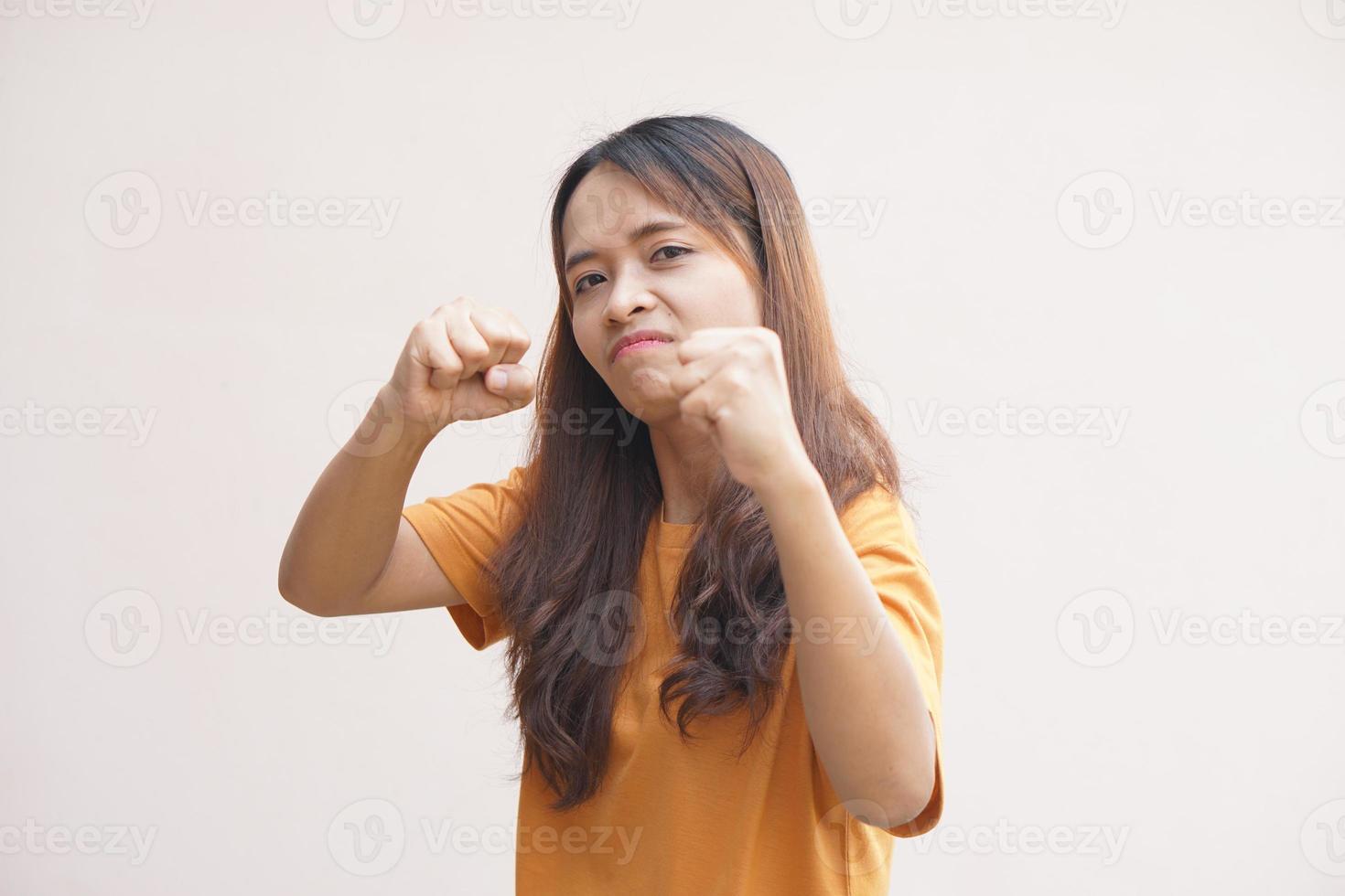 asiático mujer levantamiento su puño fuera de ira foto
