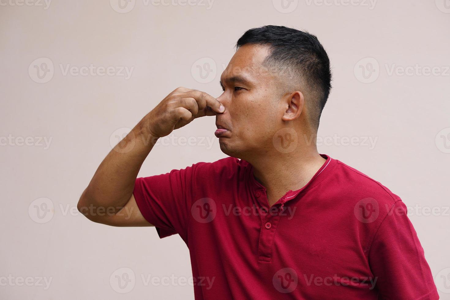 men pinch their noses with their hands to avoid foul odors. photo