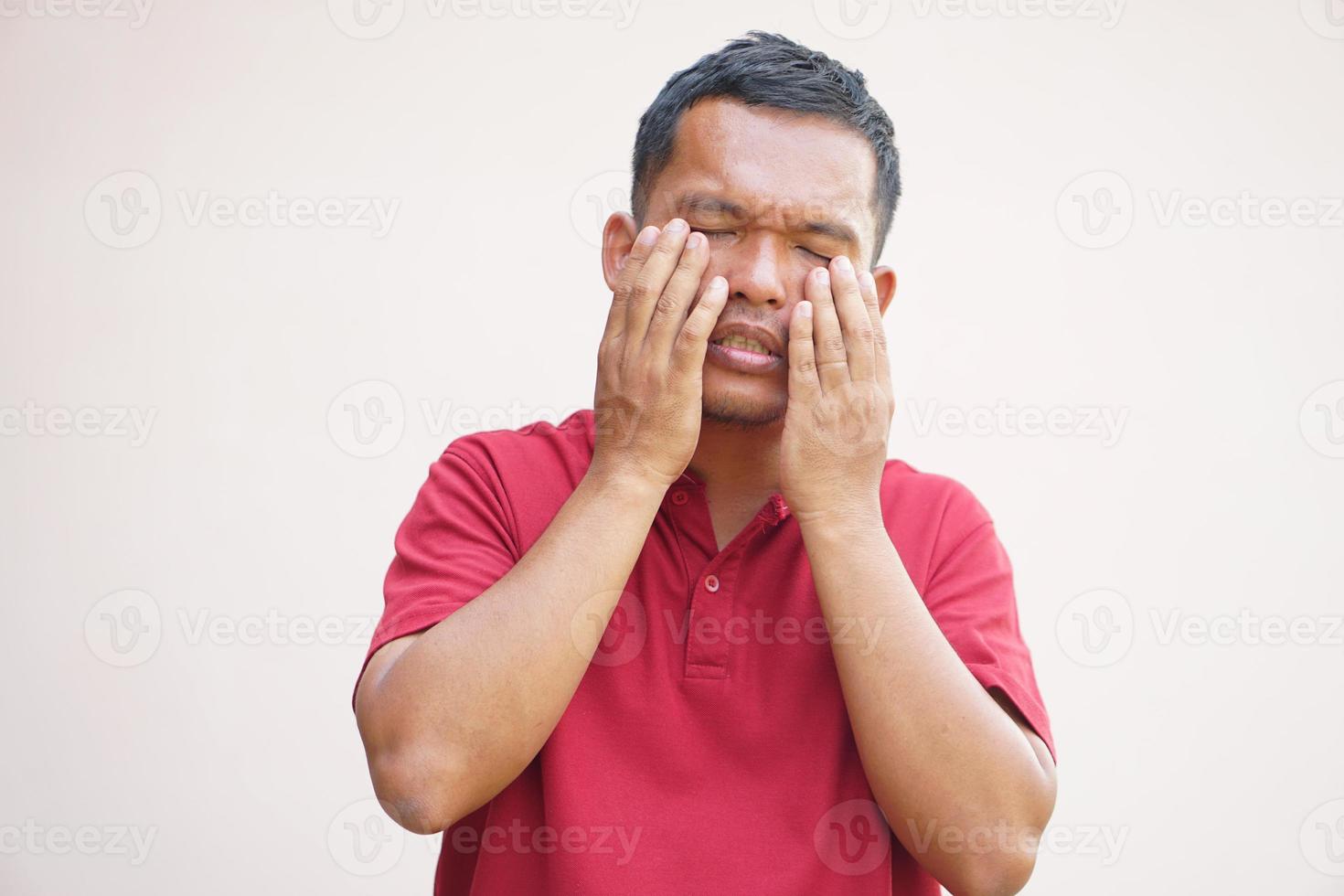 Asian man has eyestrain from looking at the computer photo