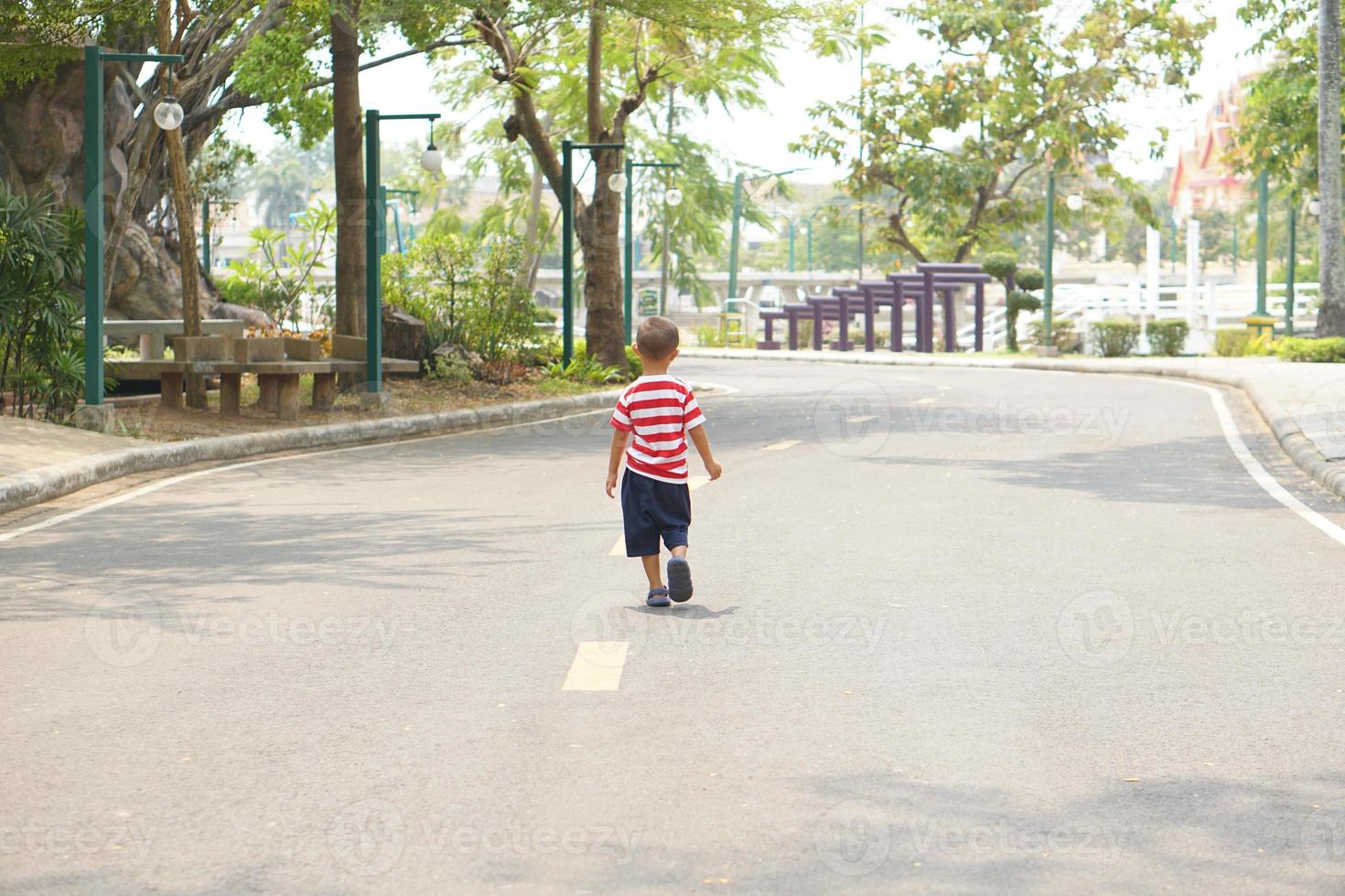 A boy running on the street in the park photo