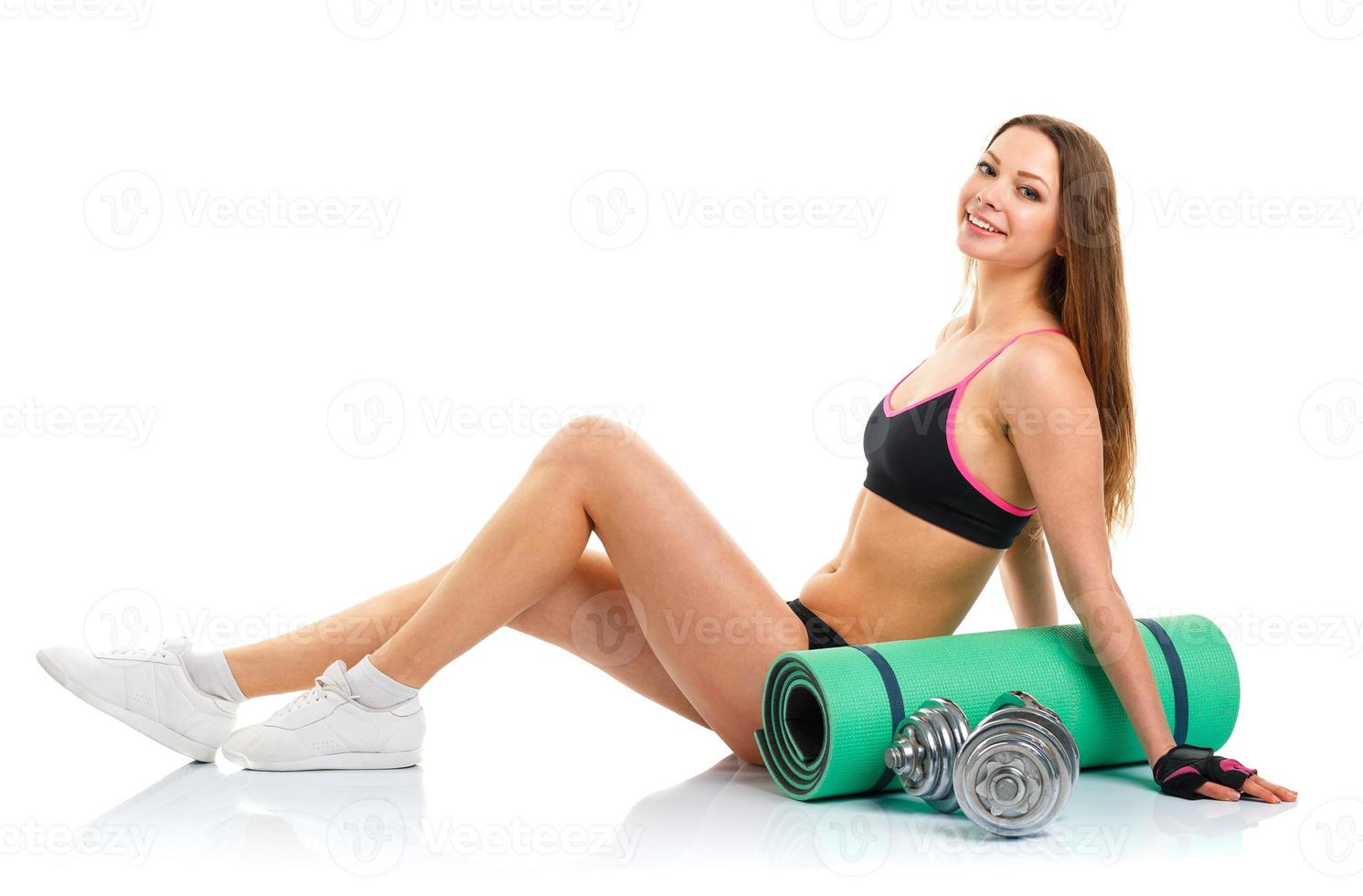 Beautiful sport woman with dumbbells and mat for fitness isolated on white photo