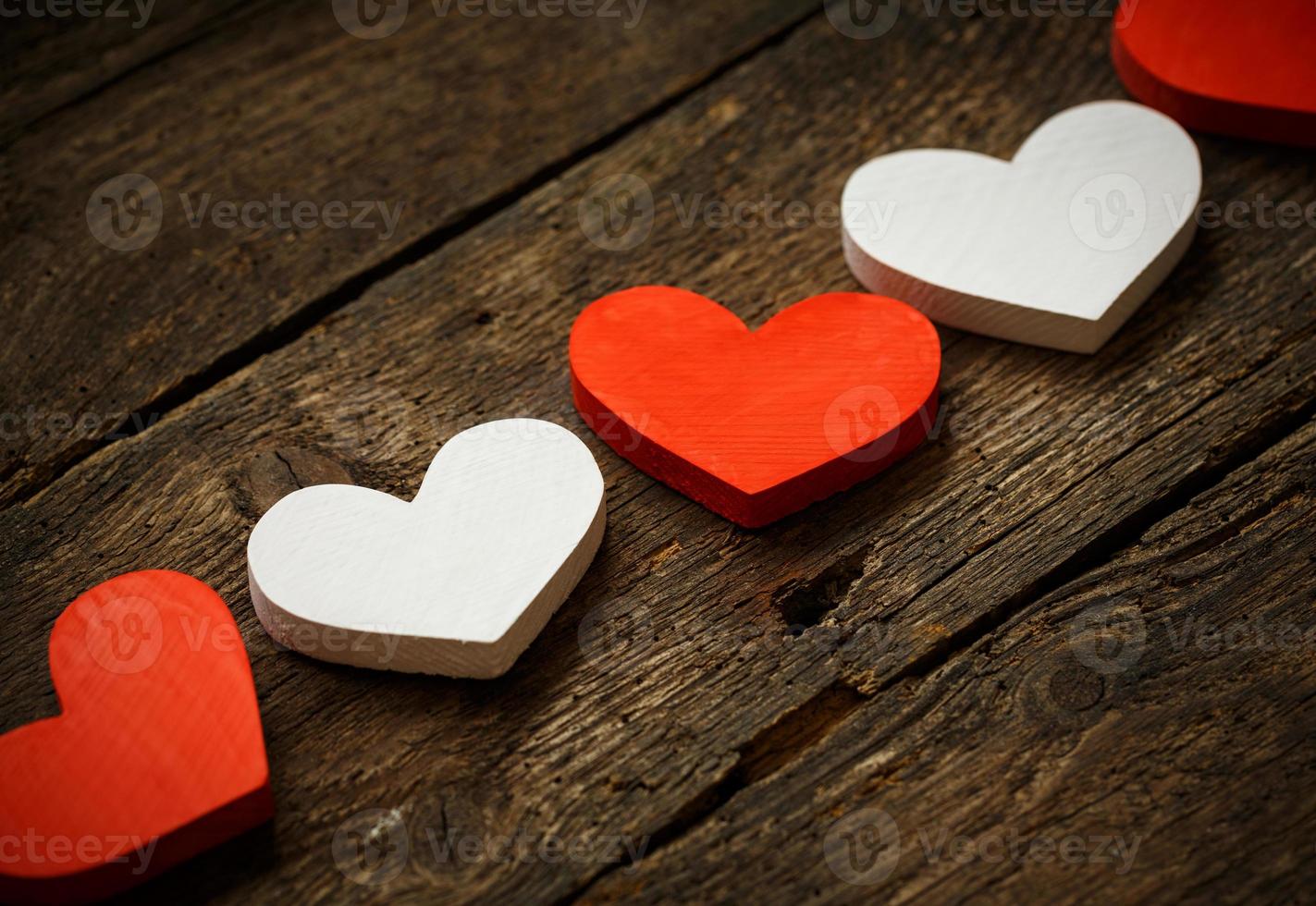 Red and white hearts on old shabby wooden background photo