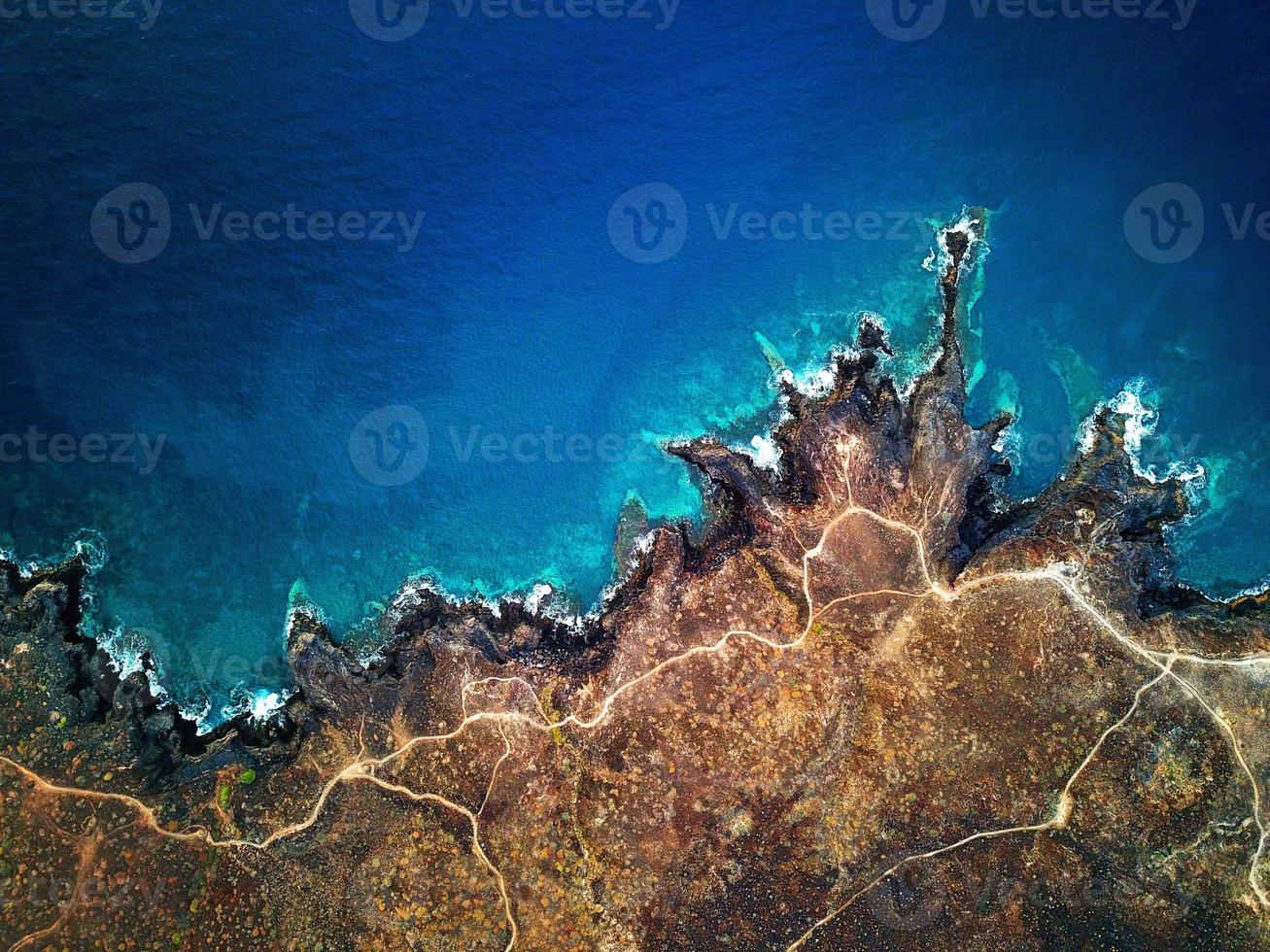 Top view of a deserted coast. Rocky shore of the island of Tenerife. Aerial drone footage of sea waves reaching shore photo