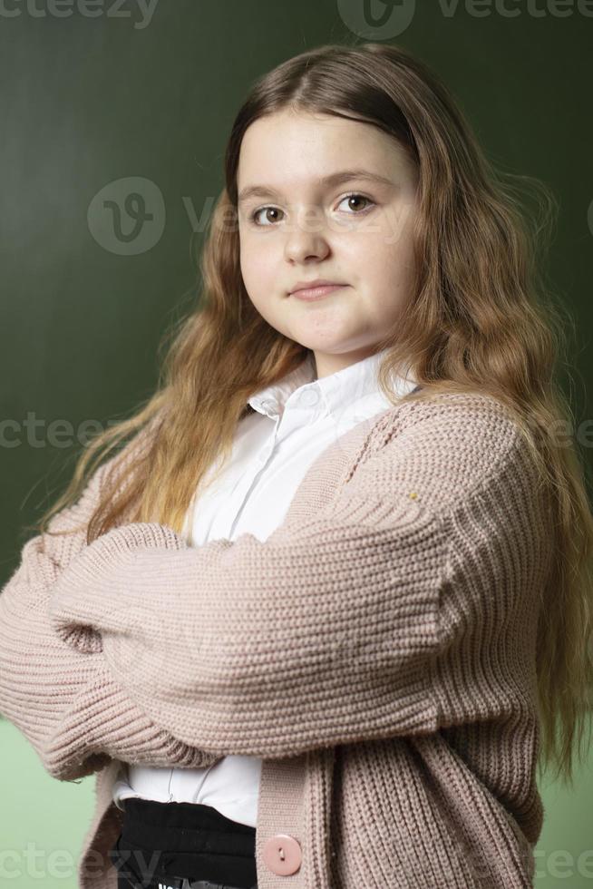 vertical retrato de un de edad mediana Chica de escuela a el pizarra. foto