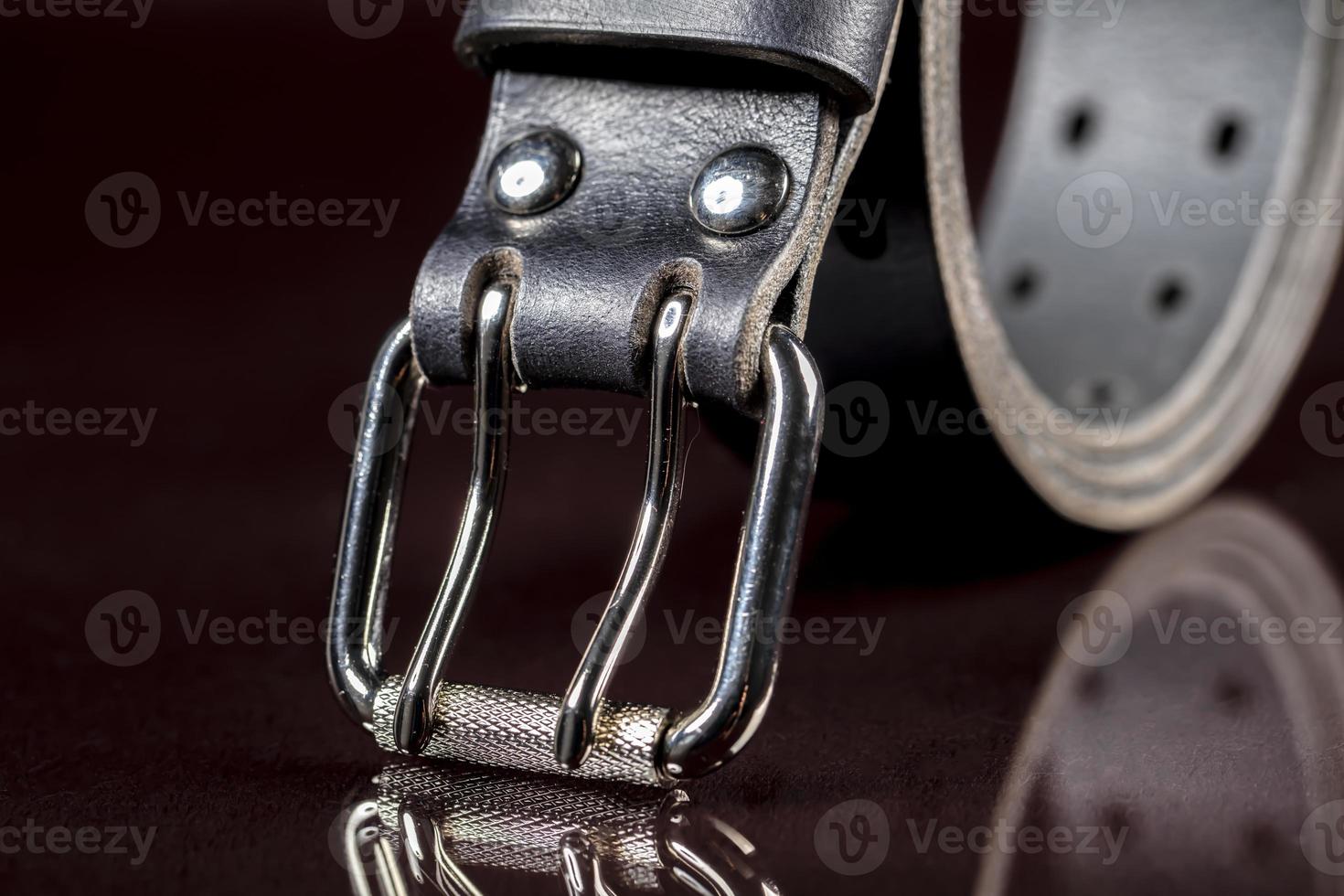 Black leather belt on a dark background. Leather products. photo