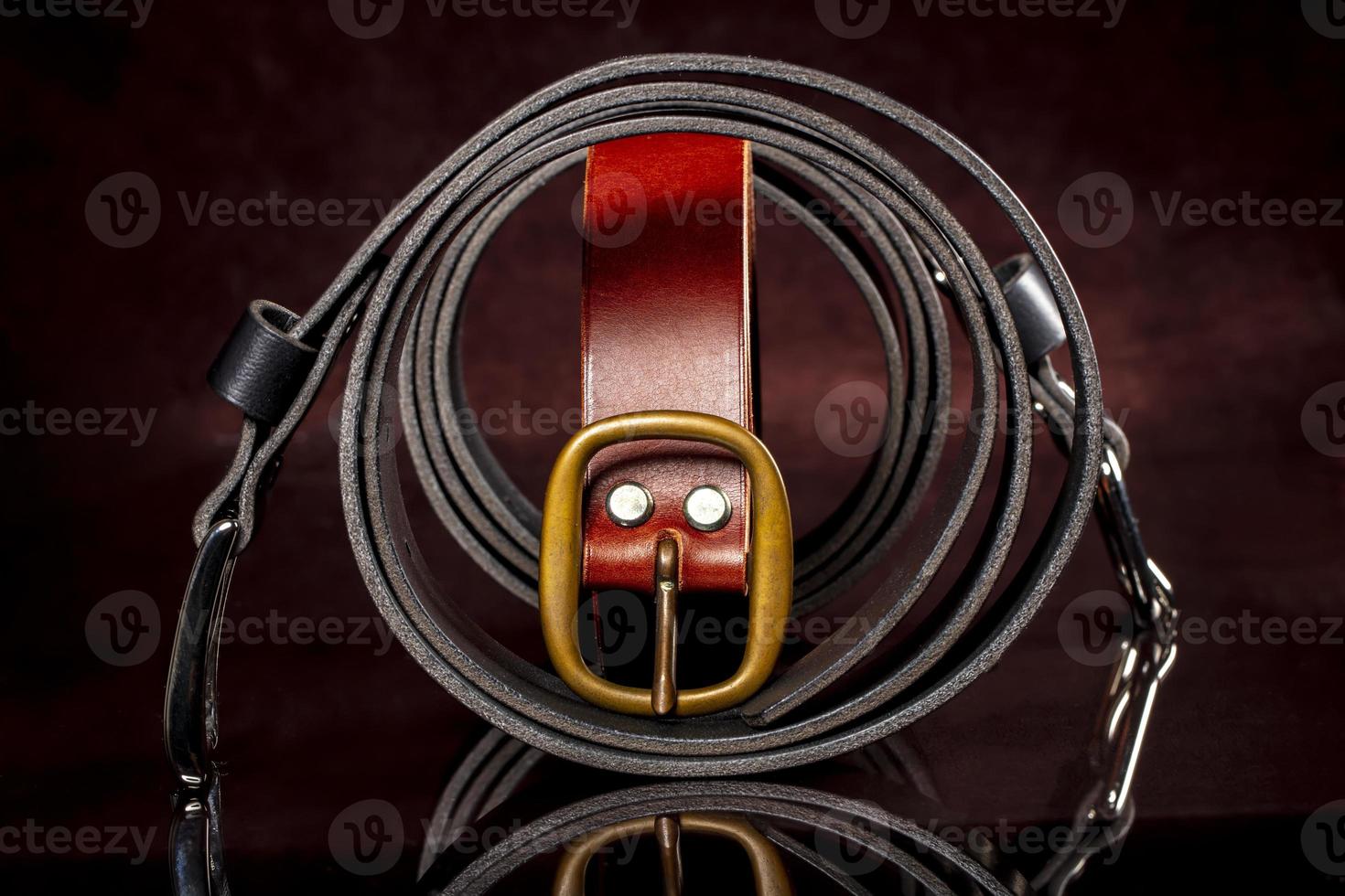 Leather belts with a buckle on a dark background. photo