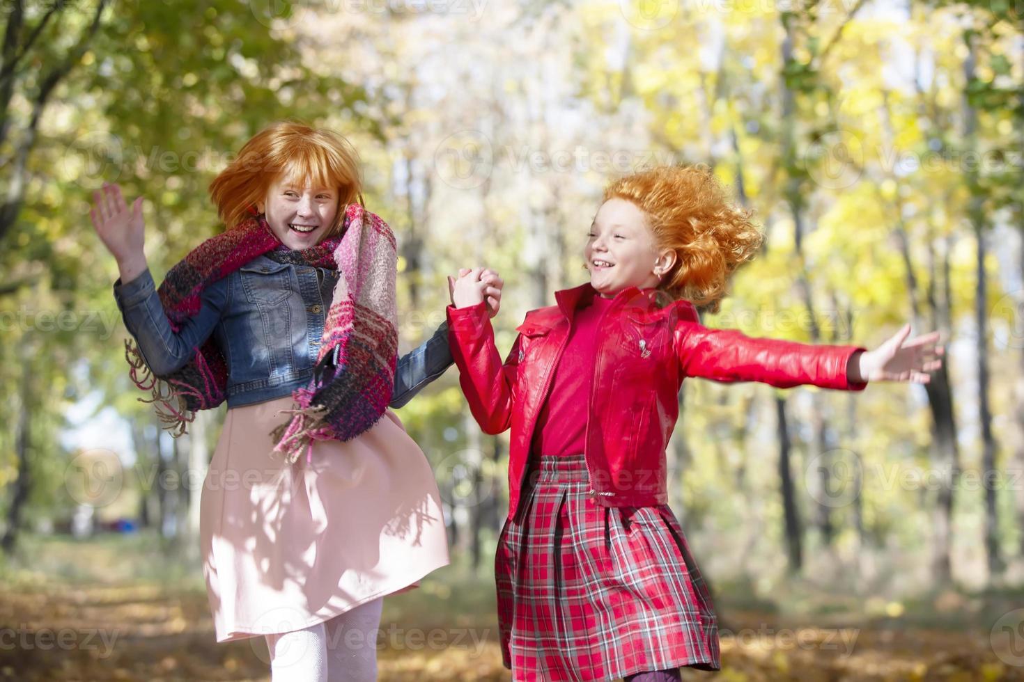 Happy children play in the autumn park on a warm sunny autumn day. photo