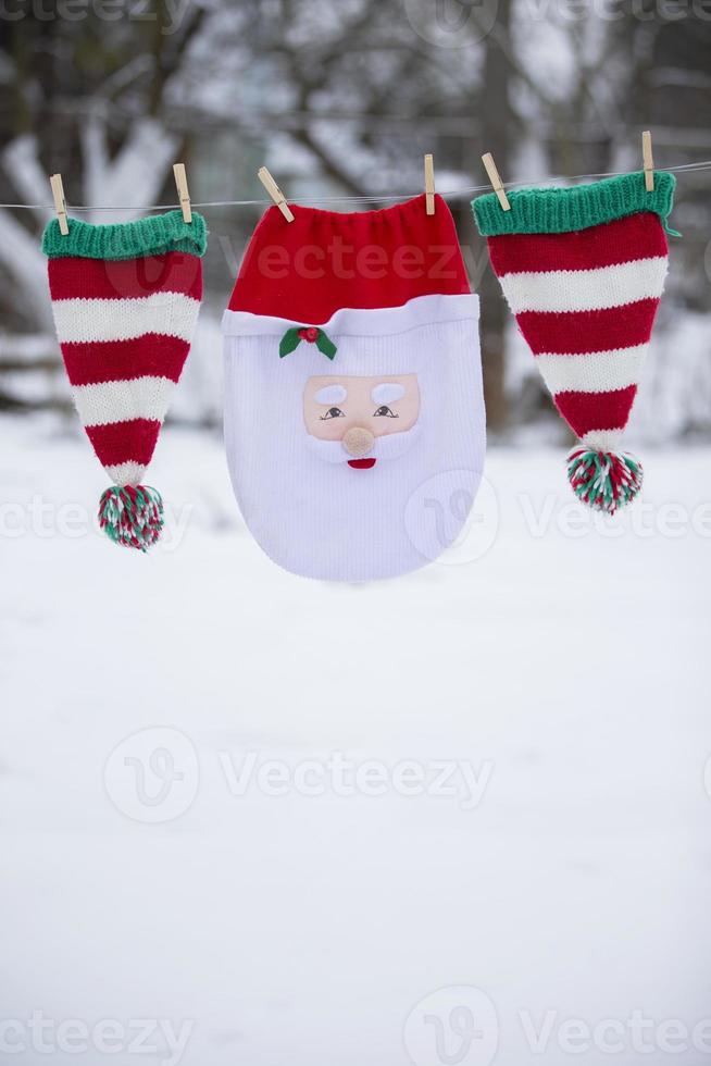 Santa's Christmas bag and striped hats are dried on a rope. Preparing to celebrate Christmas. photo