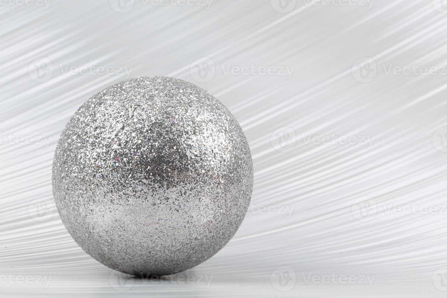 Bright festive background. A sparkling ball on a silver background. photo