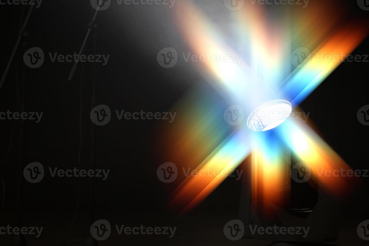 Colored multi-colored optical beam from a stage spotlight on a black background. photo