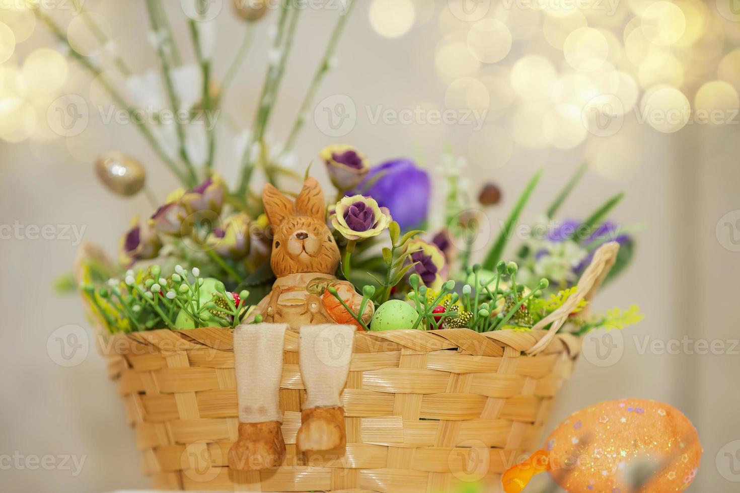 Easter basket with decorative eggs, flowers and a rabbit miniature. photo