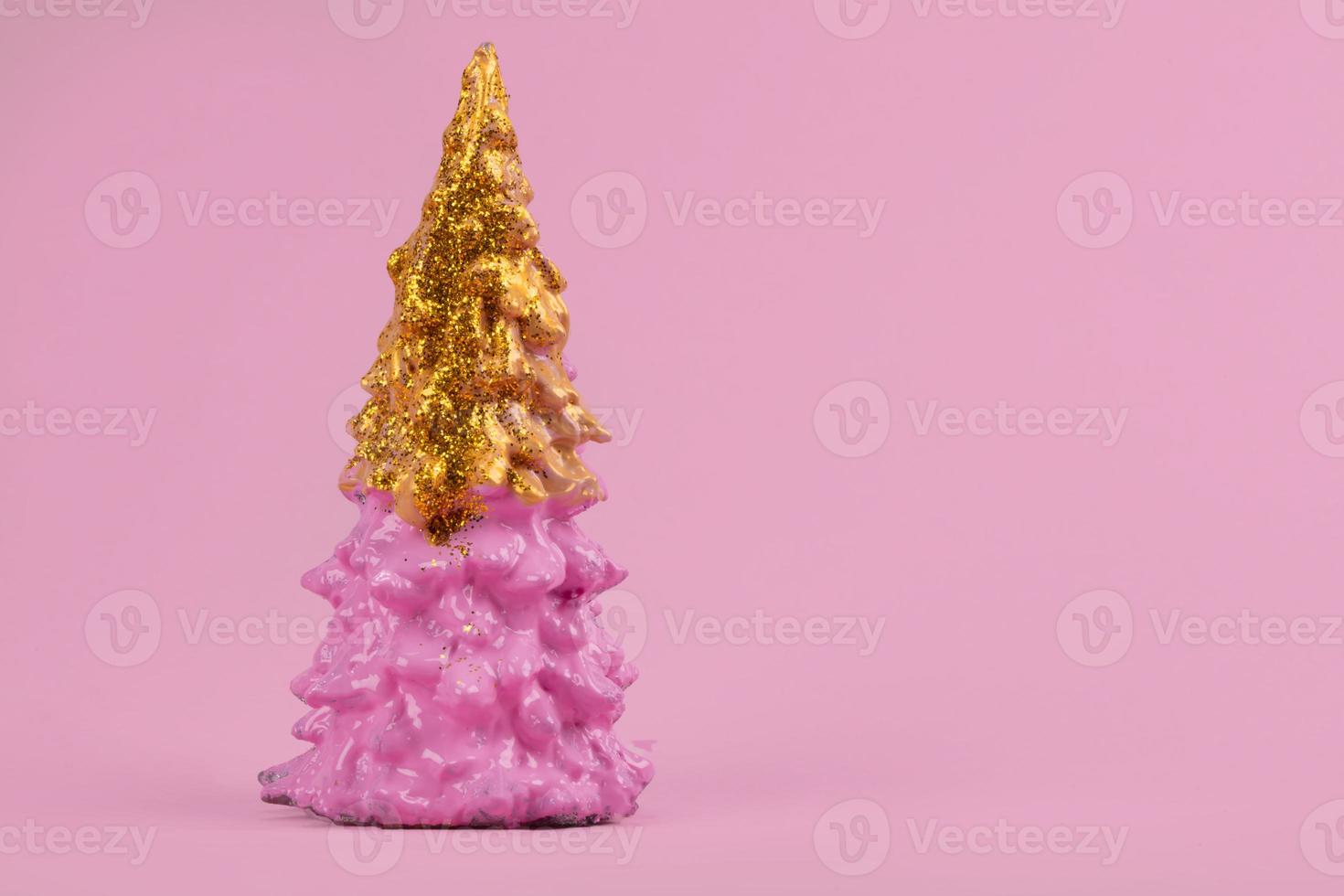 Christmas composition. Pink Christmas tree with gold on a pink background. Happy Holidays. minimal new year concept. photo