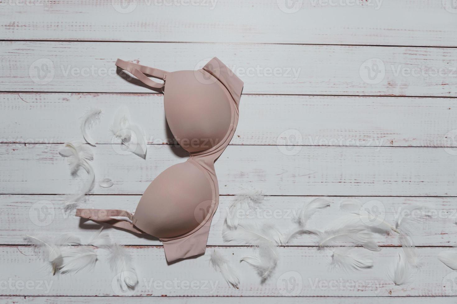 Beige bra on wooden background, closeup. photo