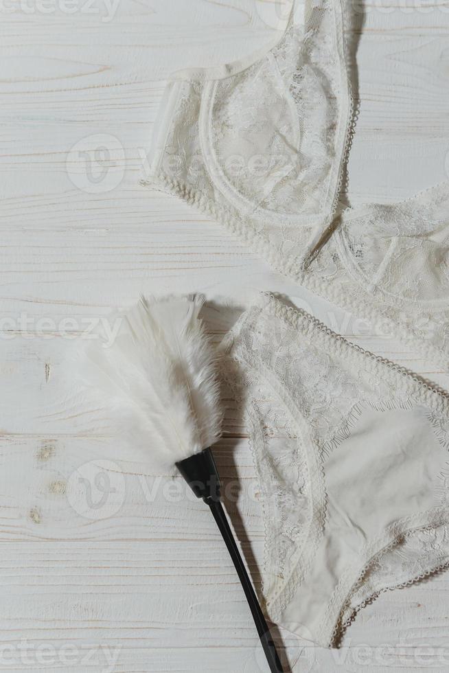 White lace bra on wooden background, closeup photo