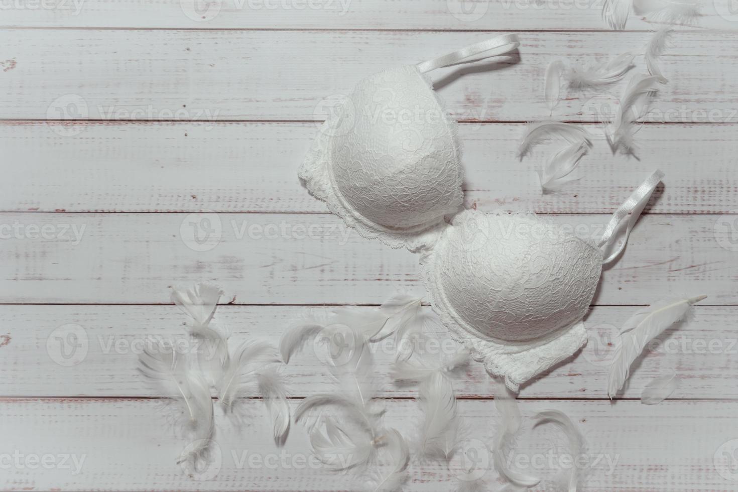 White lace bra on wooden background, closeup photo