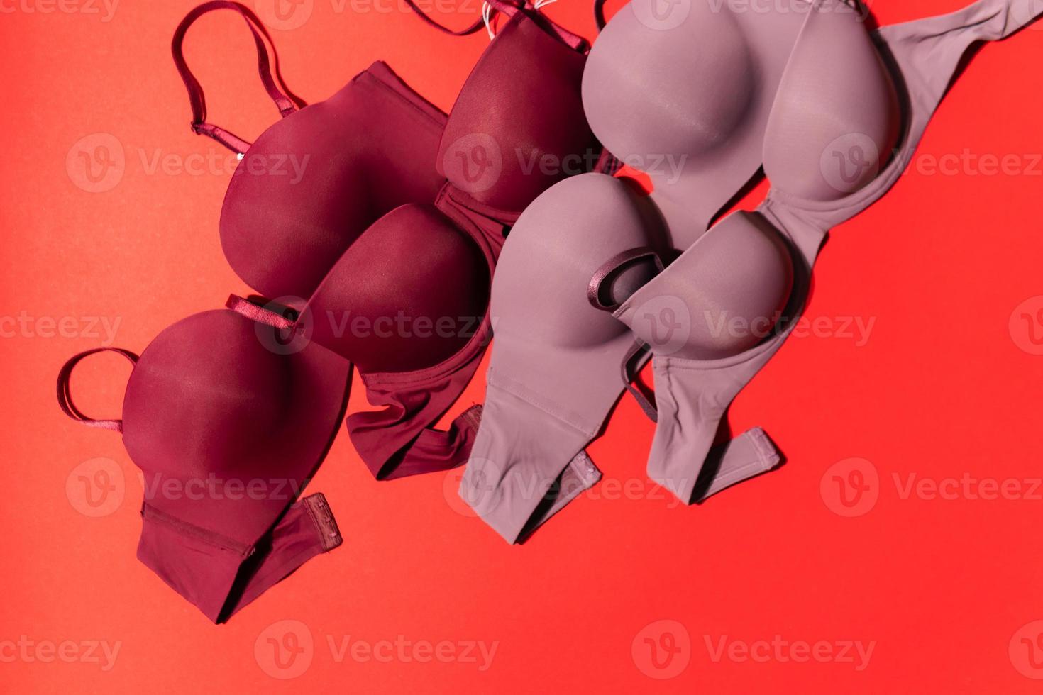 Set of colorful bra on red background, closeup. photo