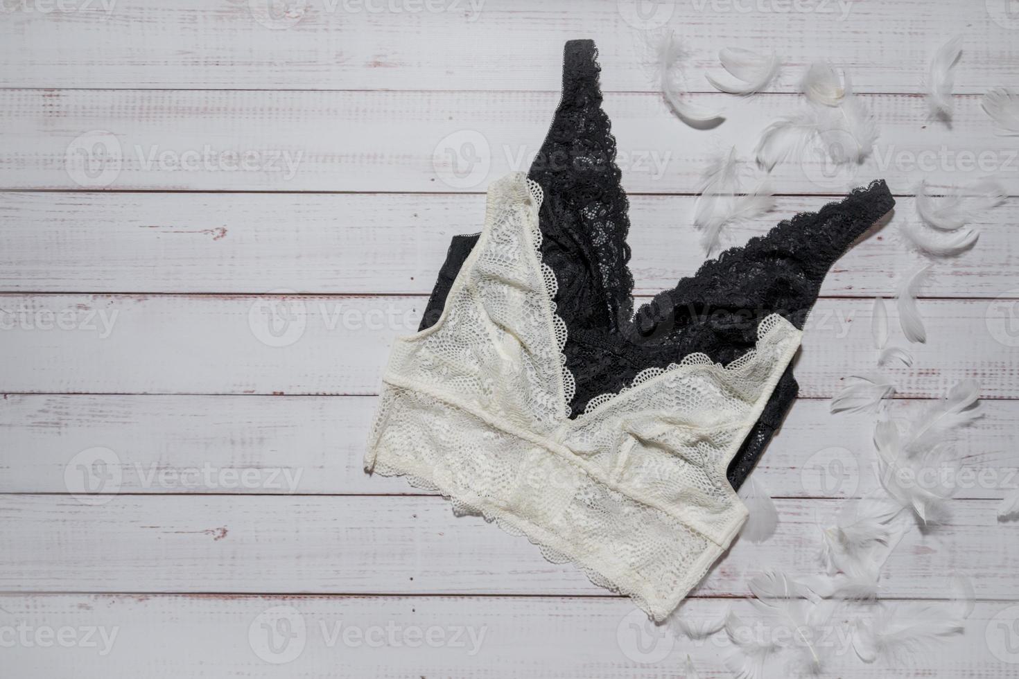 White lace bra on wooden background, closeup photo